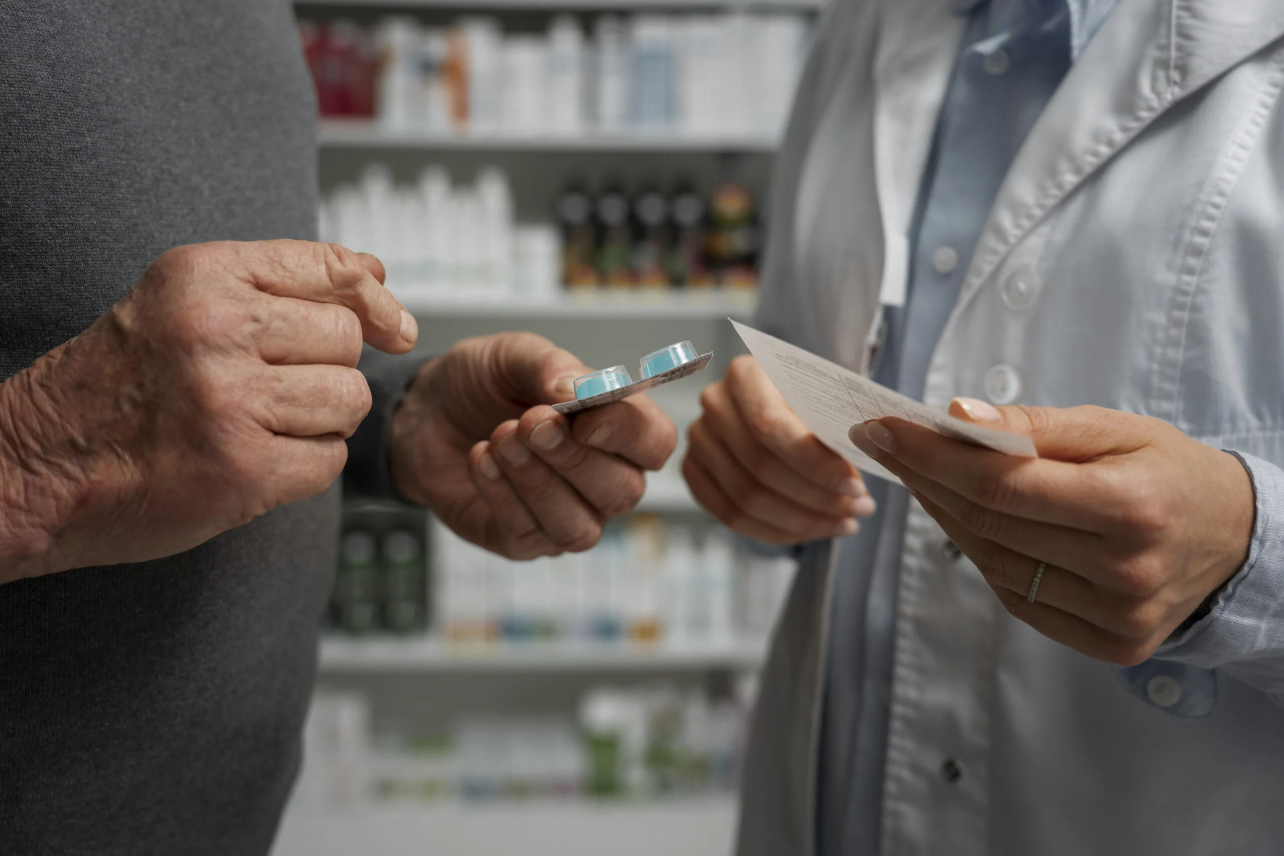 Hombre mayor que consulta a una farmacéutica sobre medicamentos